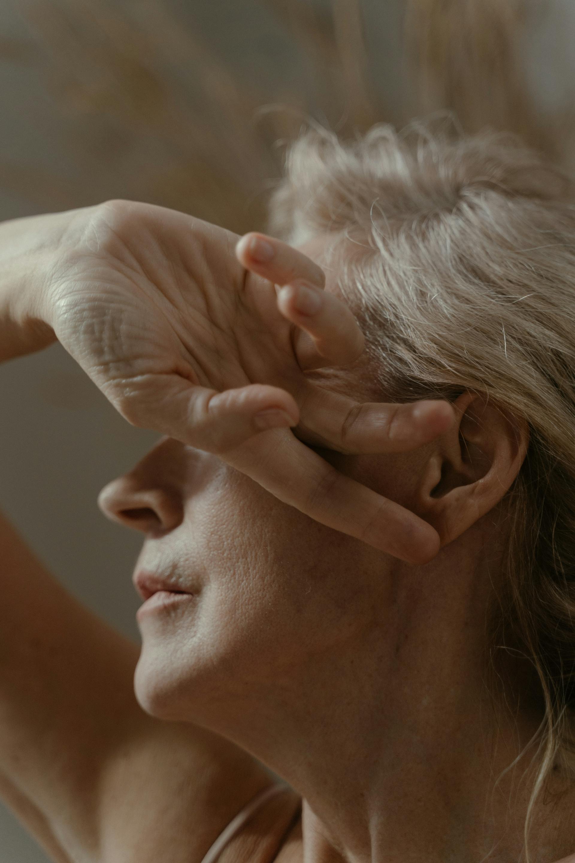 A woman covering her face with one hand | Source: Pexels