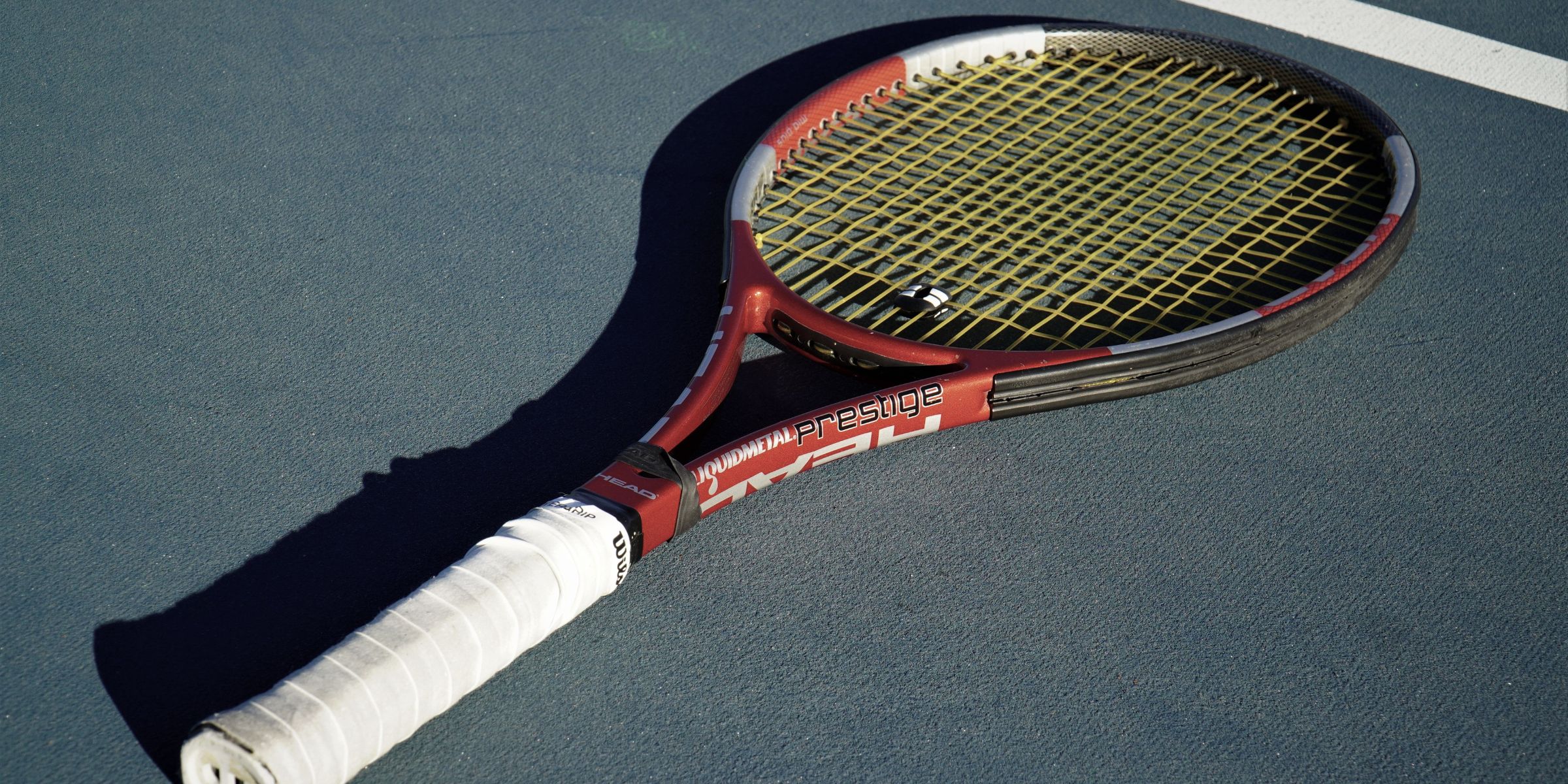 A close-up of a tennis racket on a tennis court | Source: Pexels