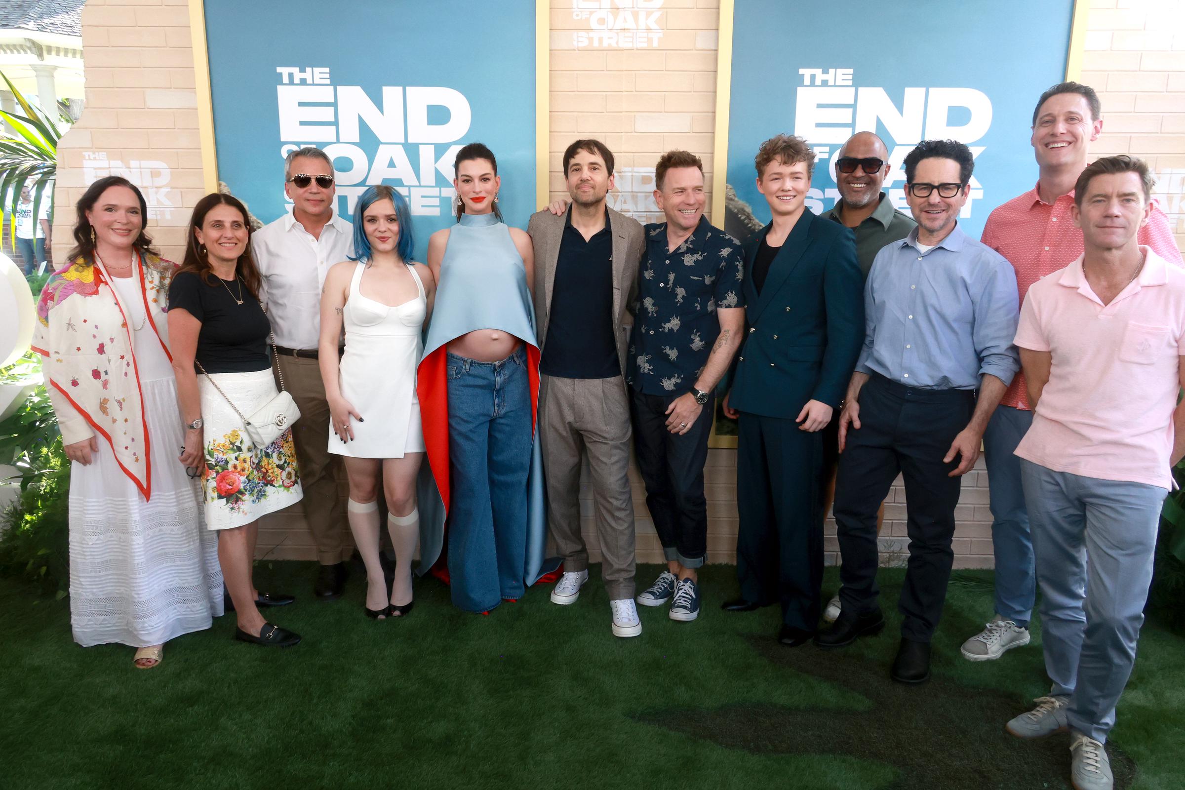 (L-R) Hannah Minghella, Head of Feature Animation, Netflix, Pamela Abdy, Co-Chair & CEO, Warner Bros. Motion Picture Group, Michael De Luca, Co-Chair & CEO, Warner Bros. Motion Picture Group, Maisy Stella, Anne Hathaway, David Robert Mitchell, Ewan McGregor, Christian Convery, Matt Jackson, J. J. Abrams, and Tommy Harper attend "The End Of Oak Street" Premiere/Block Party at Warner Bros. Studios on August 9, 2026 in Burbank, California. | Source: Getty Images