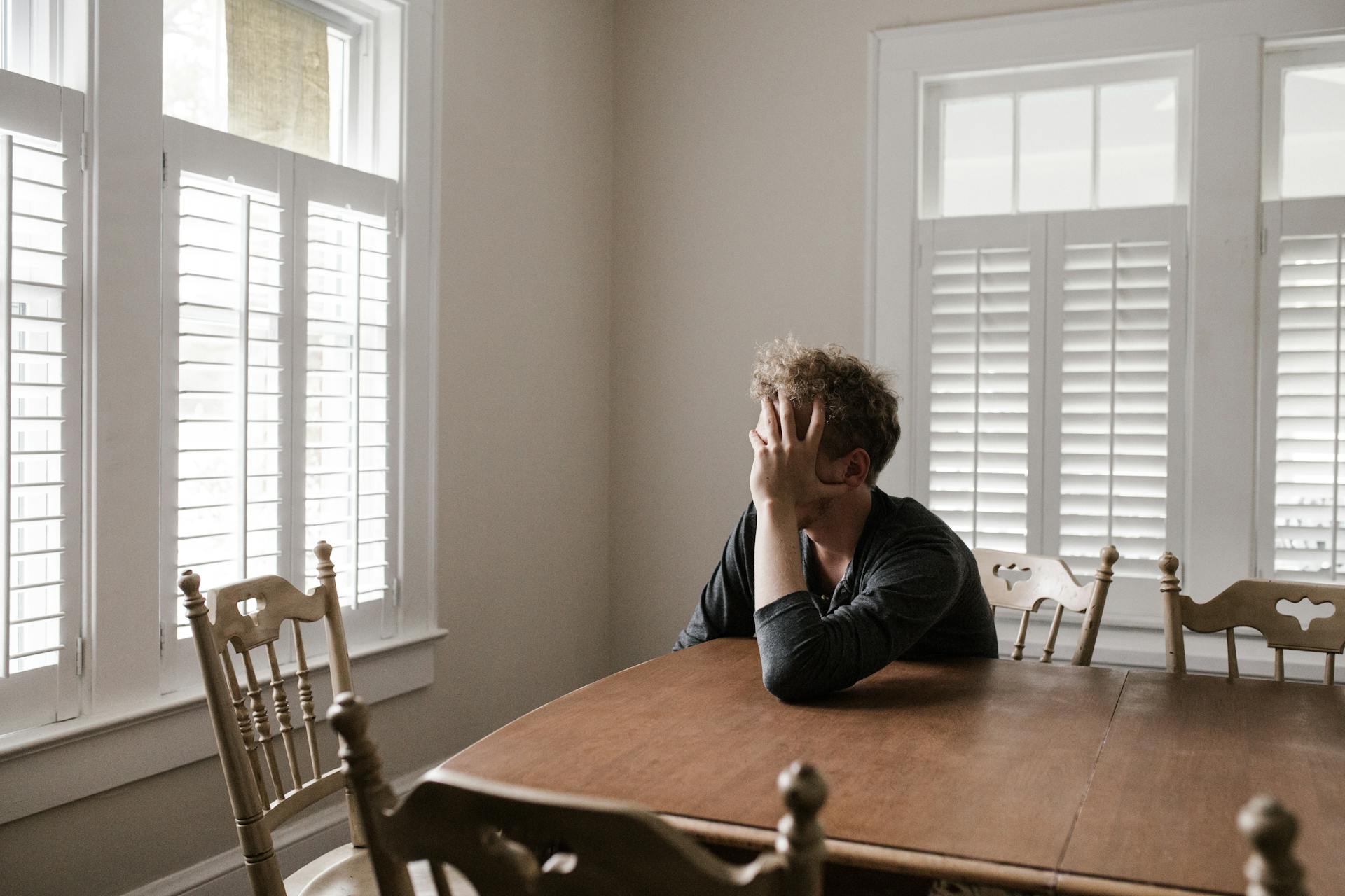 An upset man sitting at a table | Source: Pexels