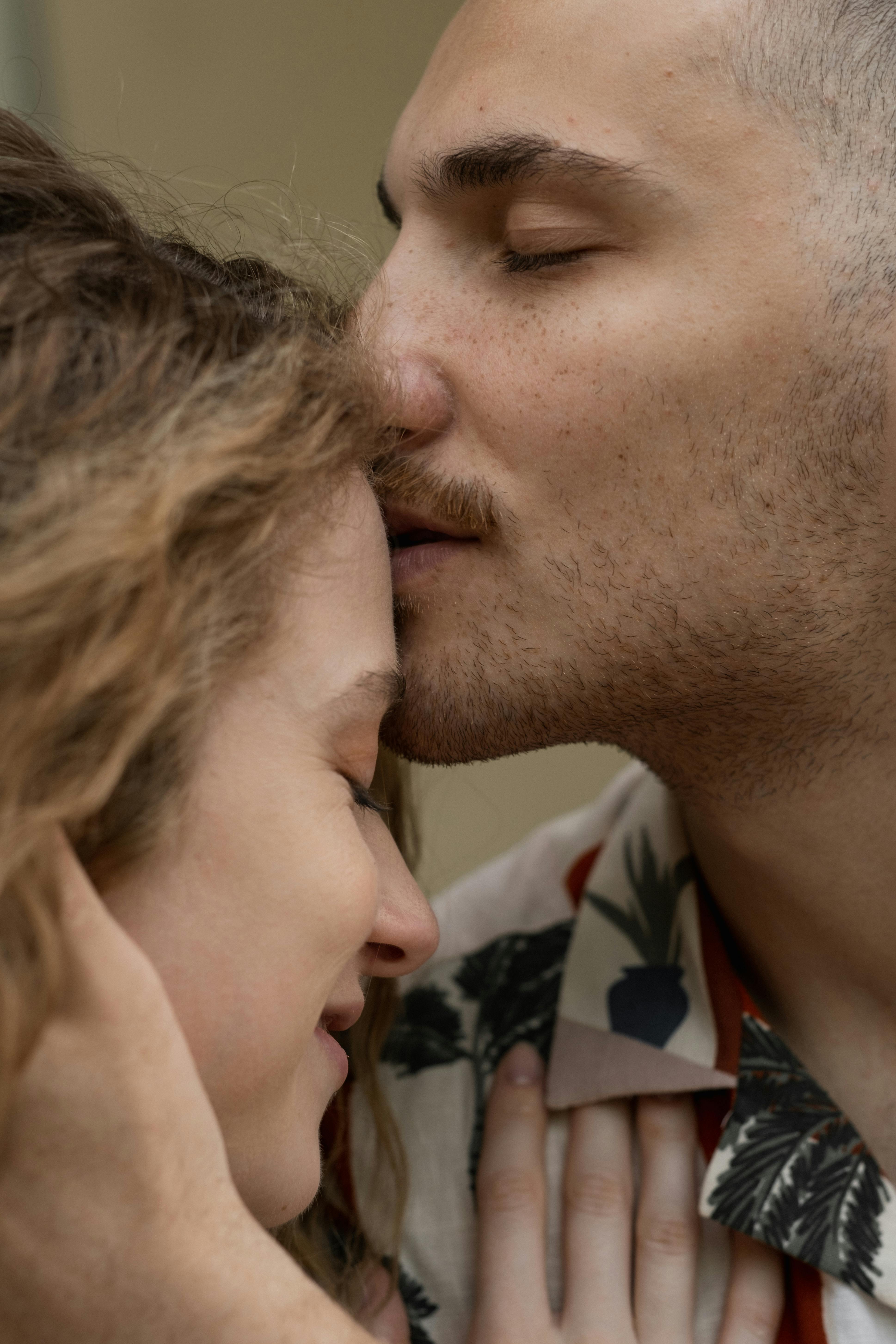A man kissing a woman's forehead | Source: Pexels
