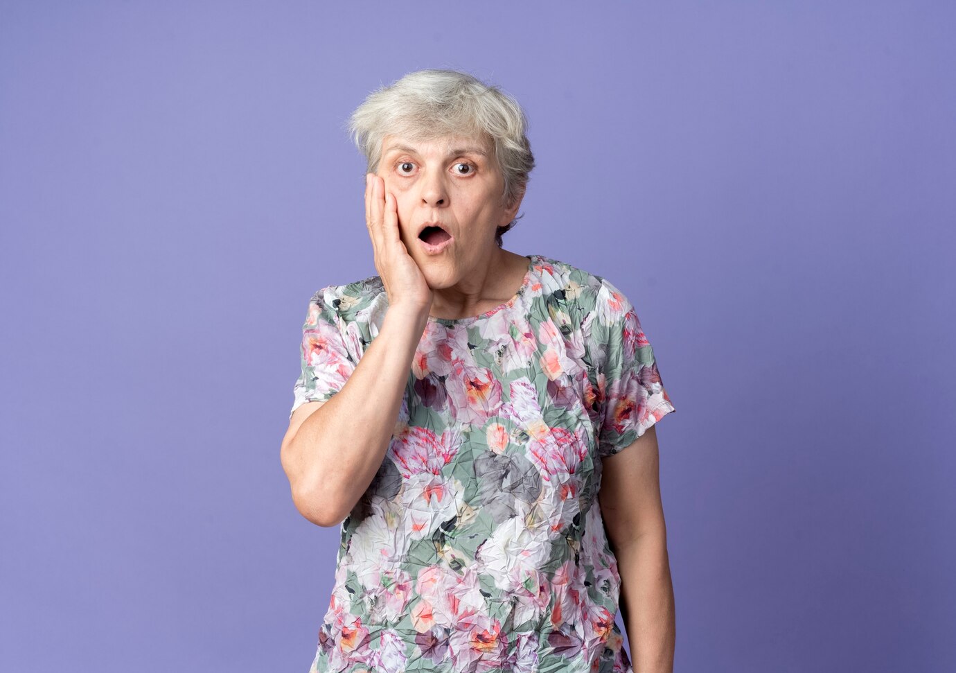 A shocked elderly woman touching her face | Source: Freepik