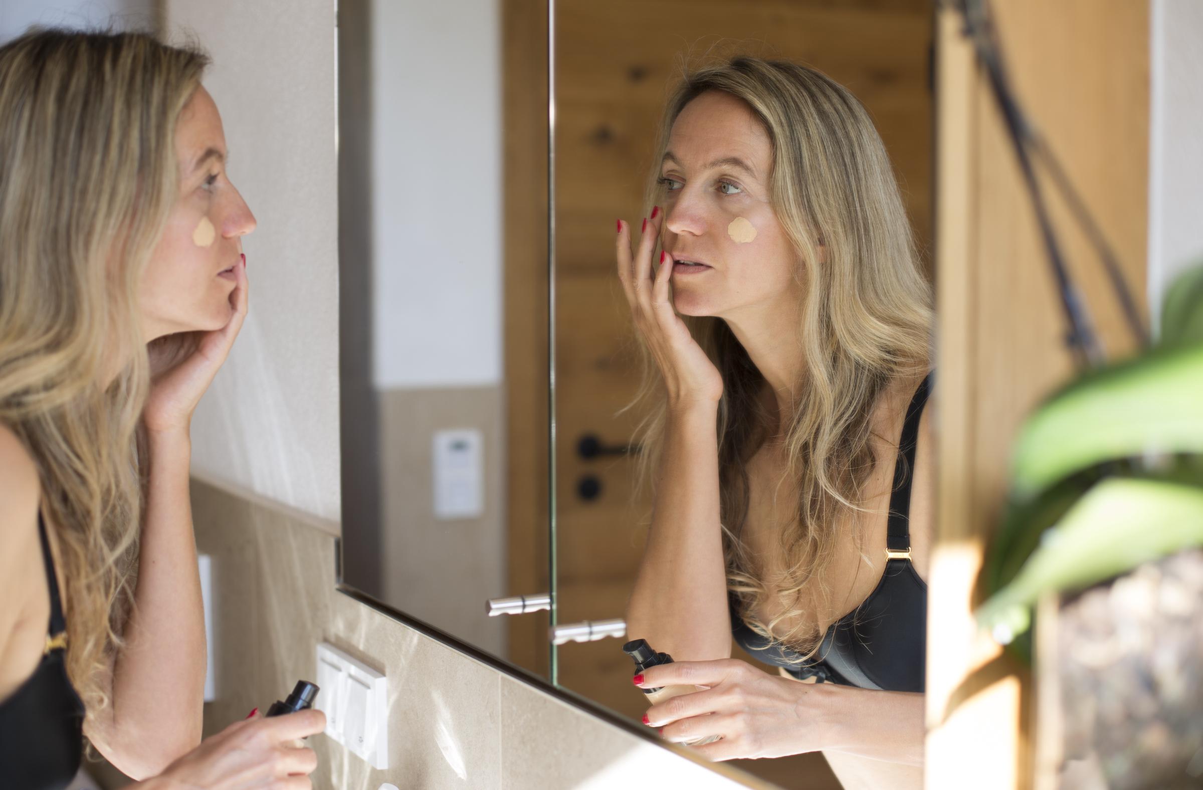 A woman applying foundation to her face with her hands | Source: Getty Images