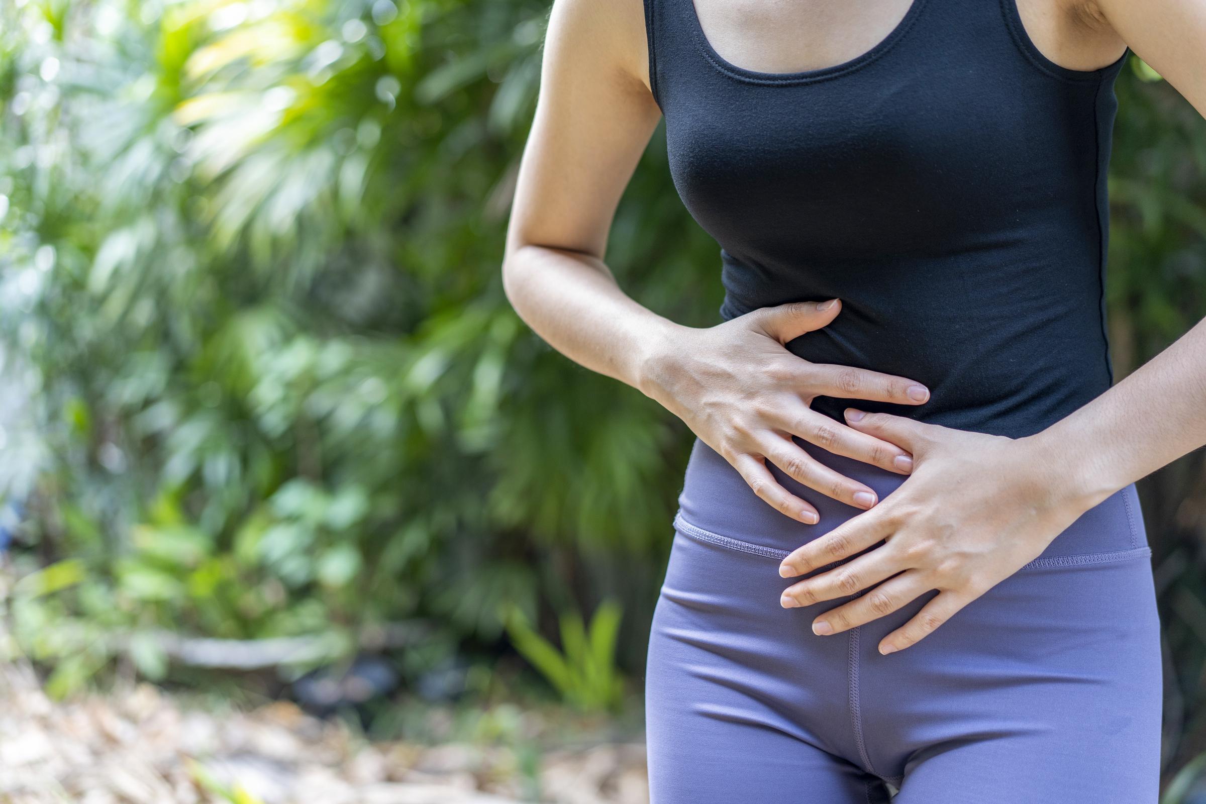 A woman clutching her stomach in pain | Source: Getty Images