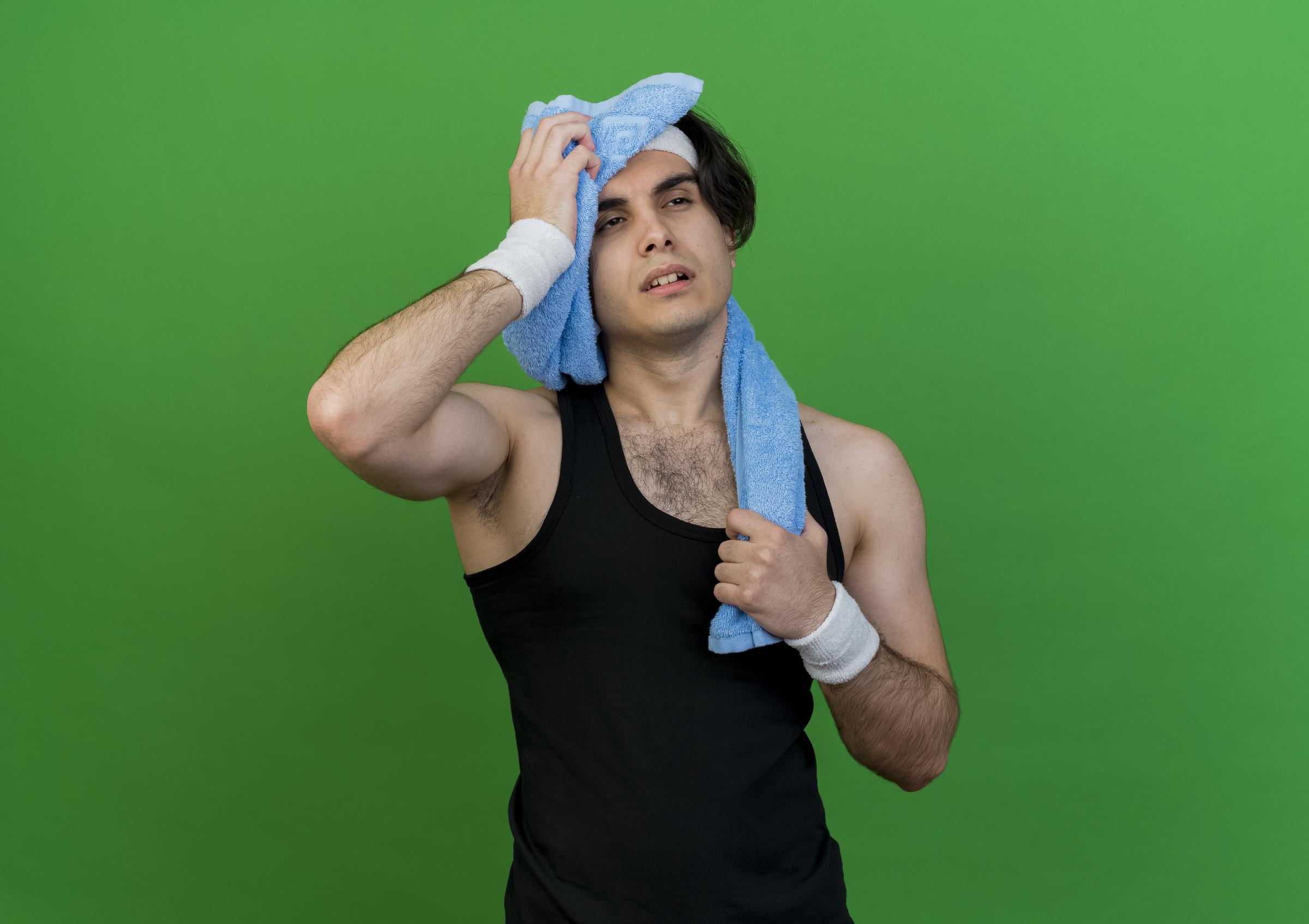 A sweaty runner wiping himself with a towel | Source: Magnific
