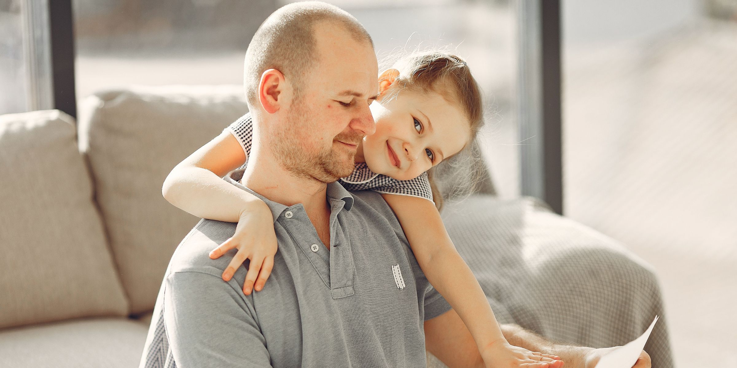 A happy daughter embracing her father while he reads a note | Source: Pexels