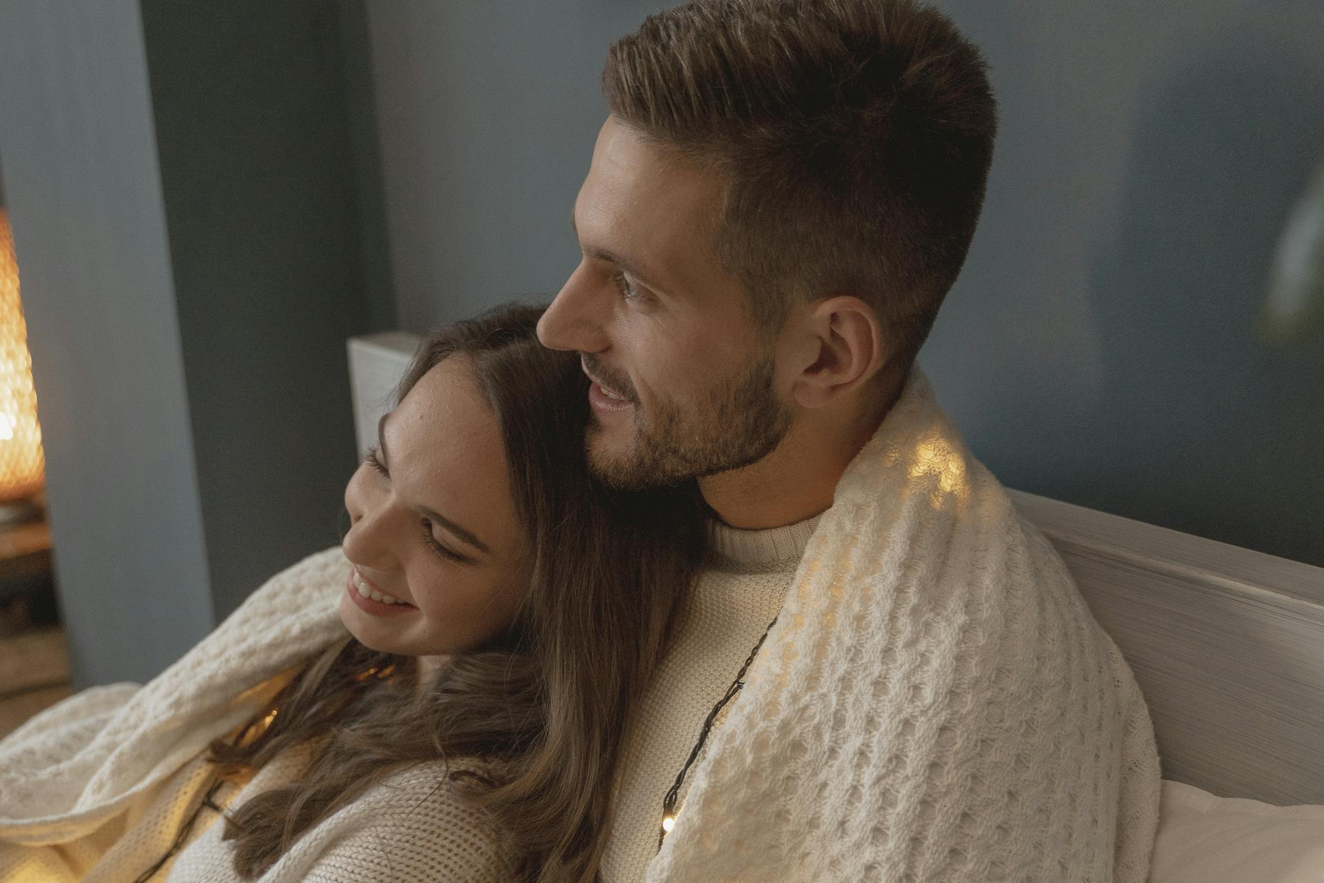 A happy couple cuddling in bed | Source: Pexels