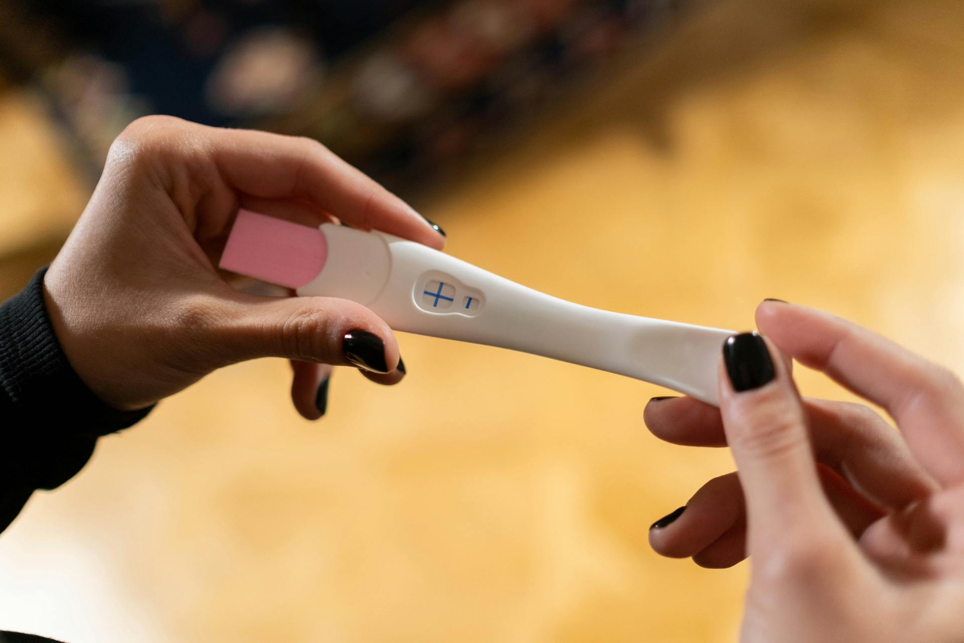 A woman holding a pregnancy test kit | Source: Pexels