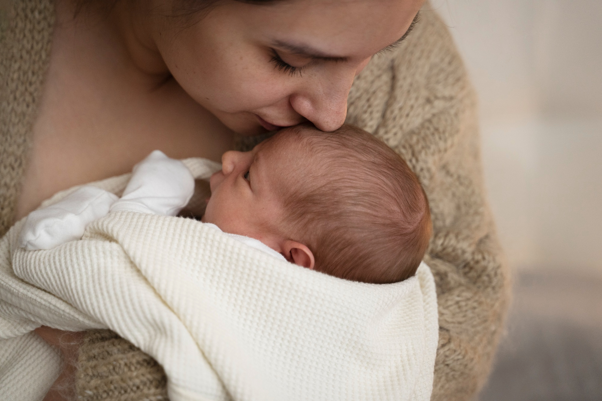 A woman kissing her baby | Source: Freepik