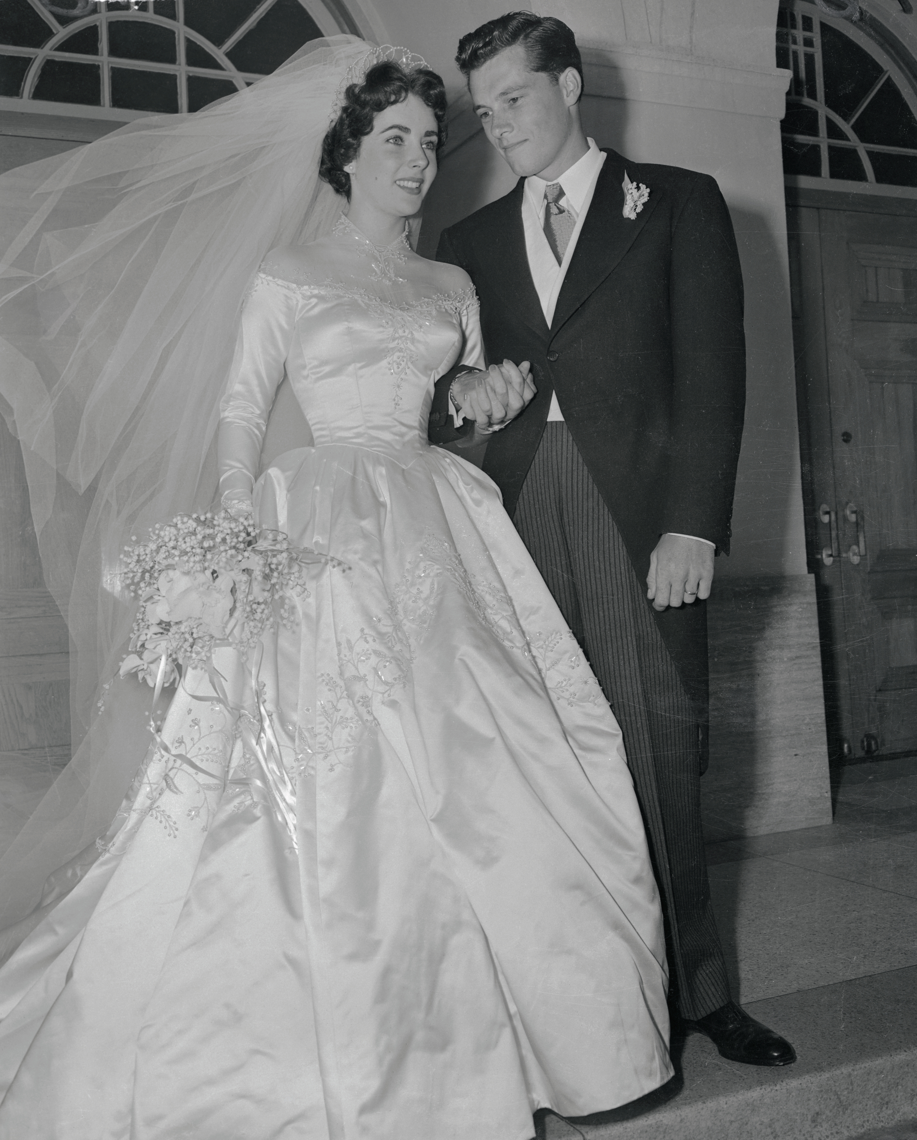 Elizabeth Taylor and Conrad "Nicky" Hilton Jr. pose outside the Church of the Good Shepherd following their wedding ceremony in 1950. | Source: Getty Images