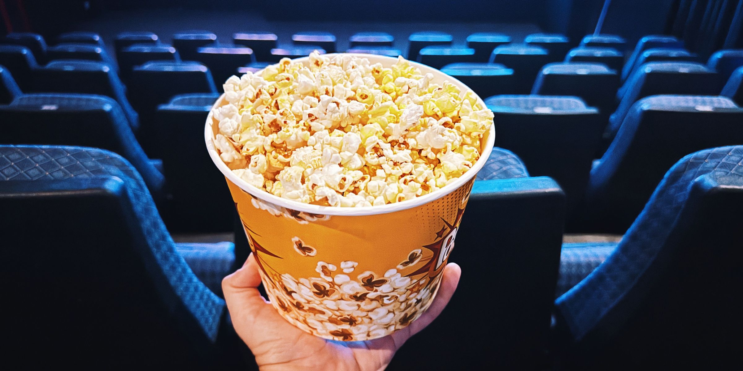 A hand holding a bucket of popcorn | Source: Getty Images