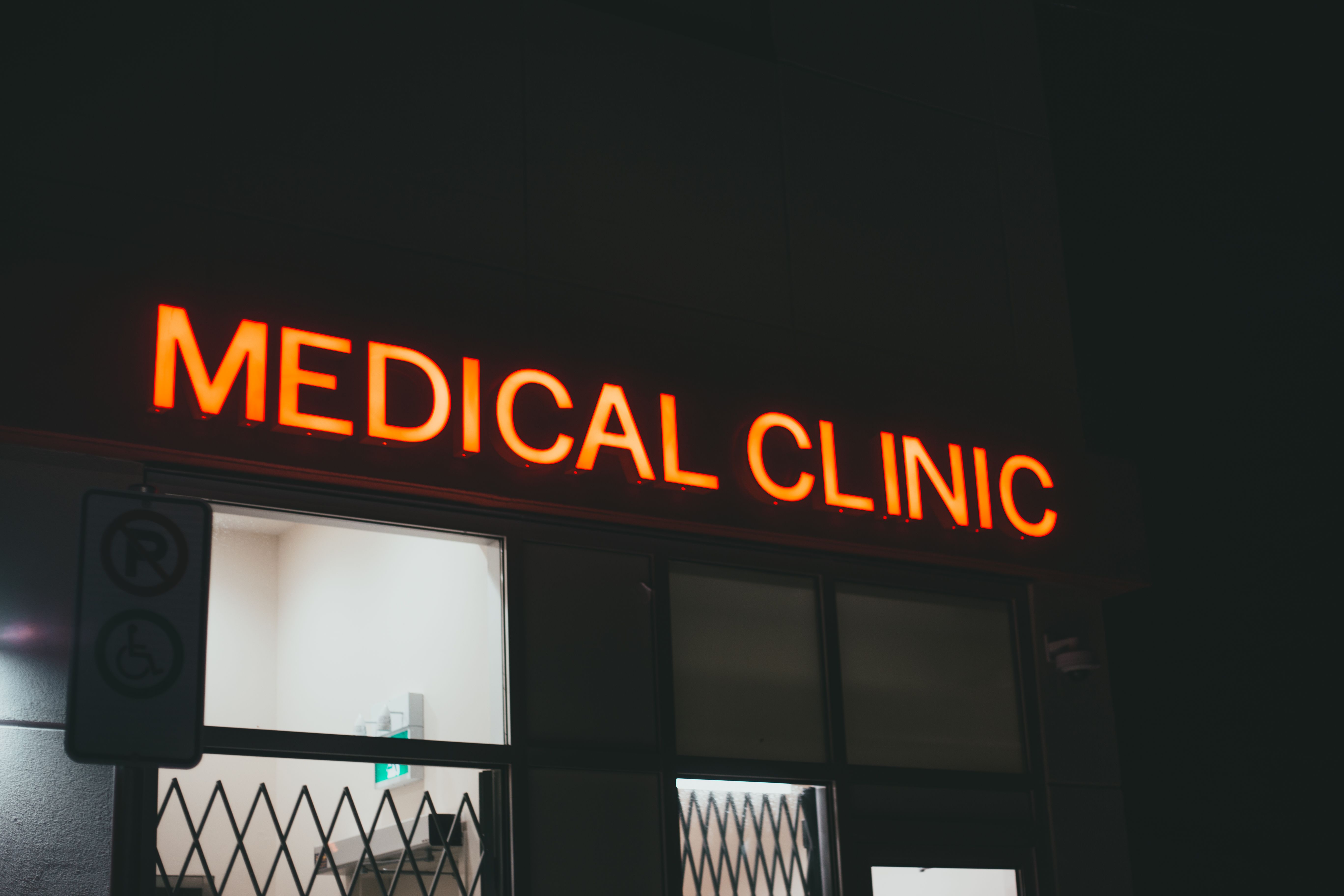A bright neon sign of a medical clinic at night, creating a vibrant street scene | Source: Pexels