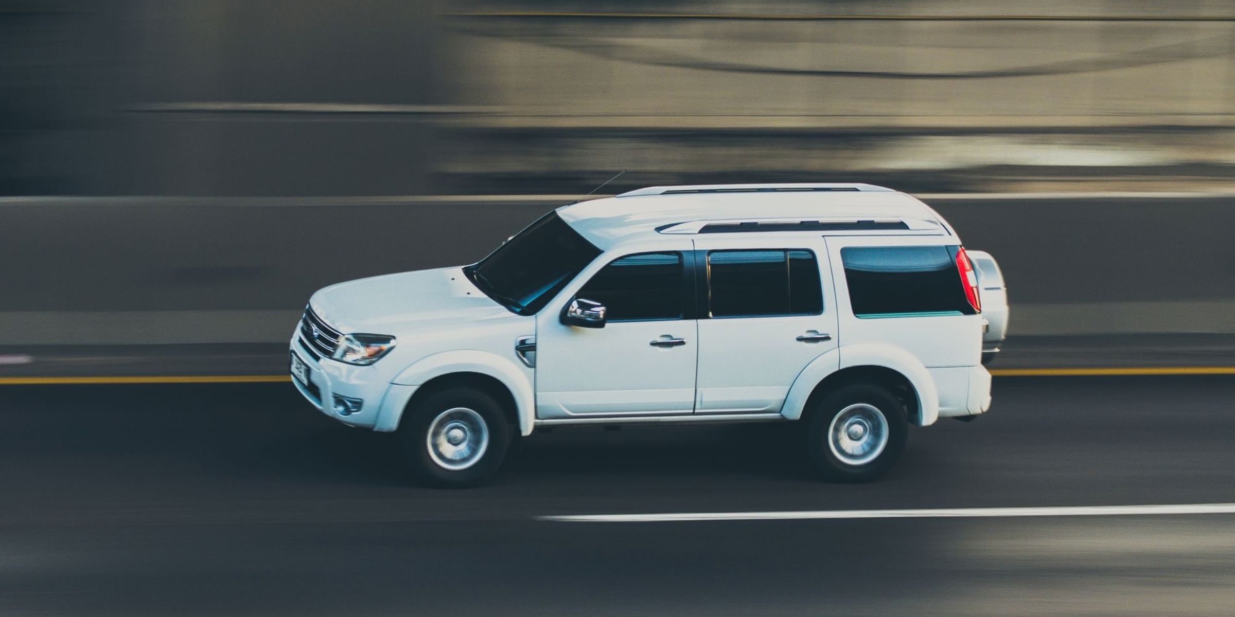 White SUV speeding along a roadway | Source: Pexels
