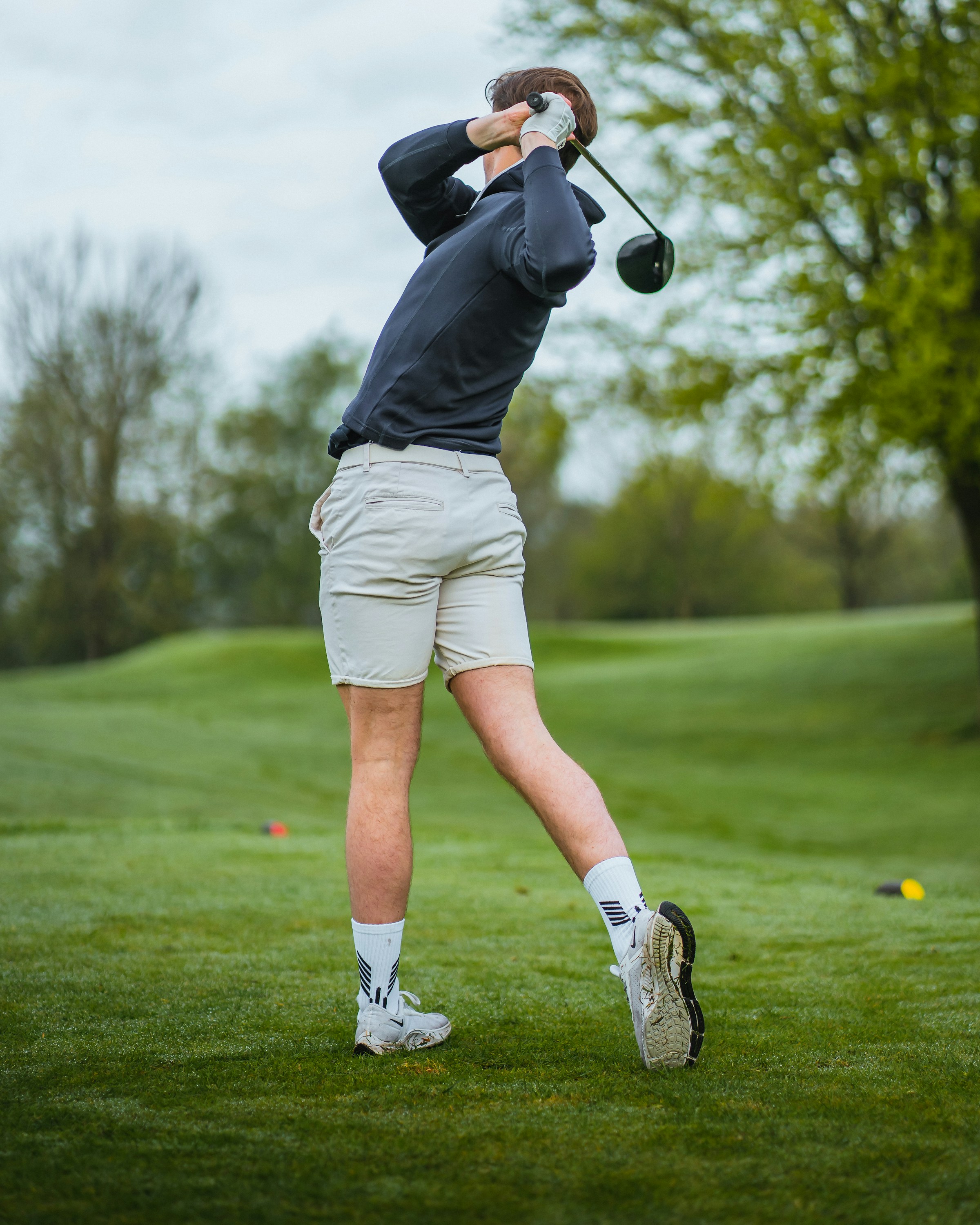 A man swinging a golf club on a golf course | Source: Unsplash