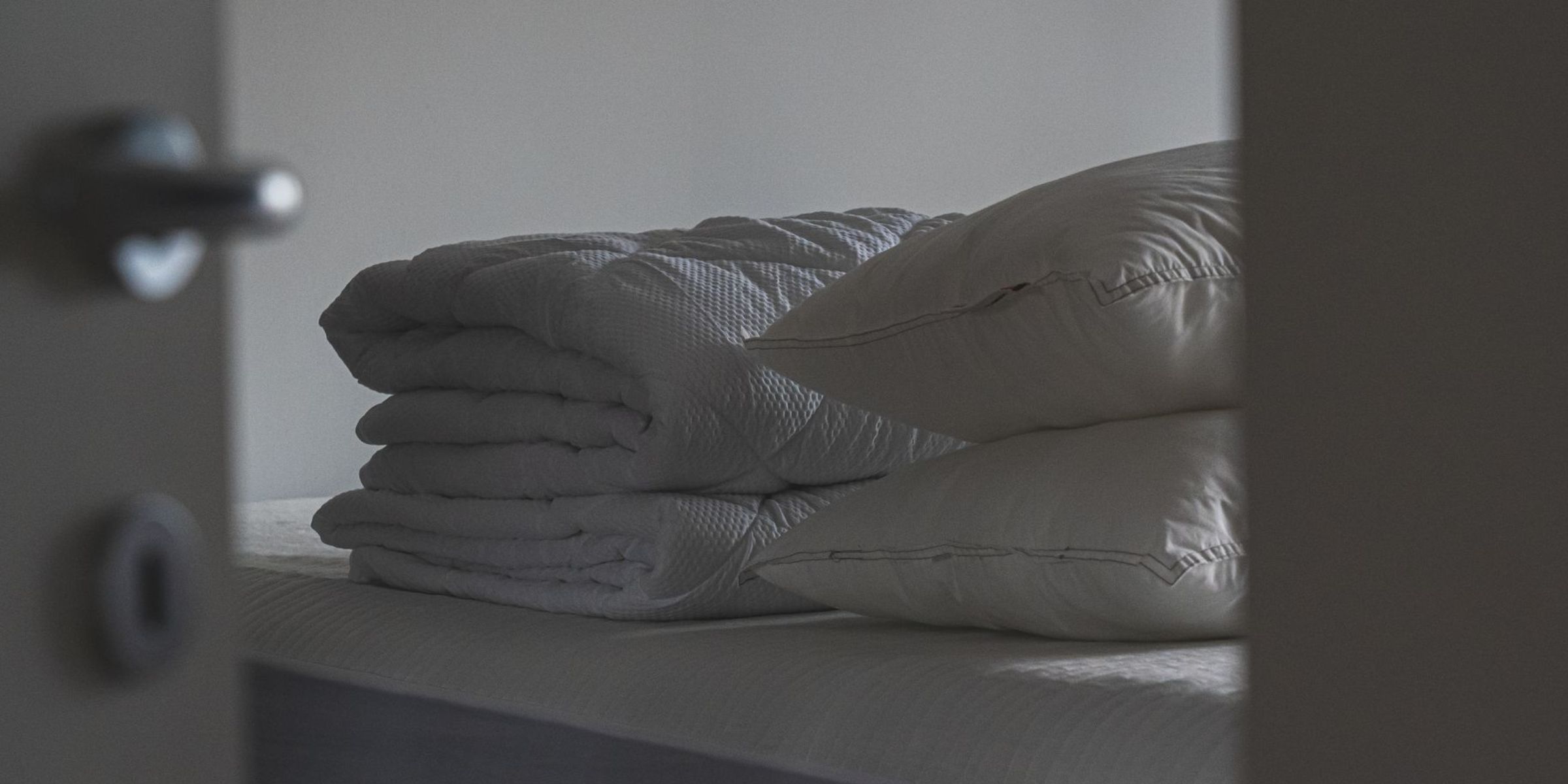 A tranquil bedroom scene with pillows piled high and blankets folded on a bed | Source: Pexels