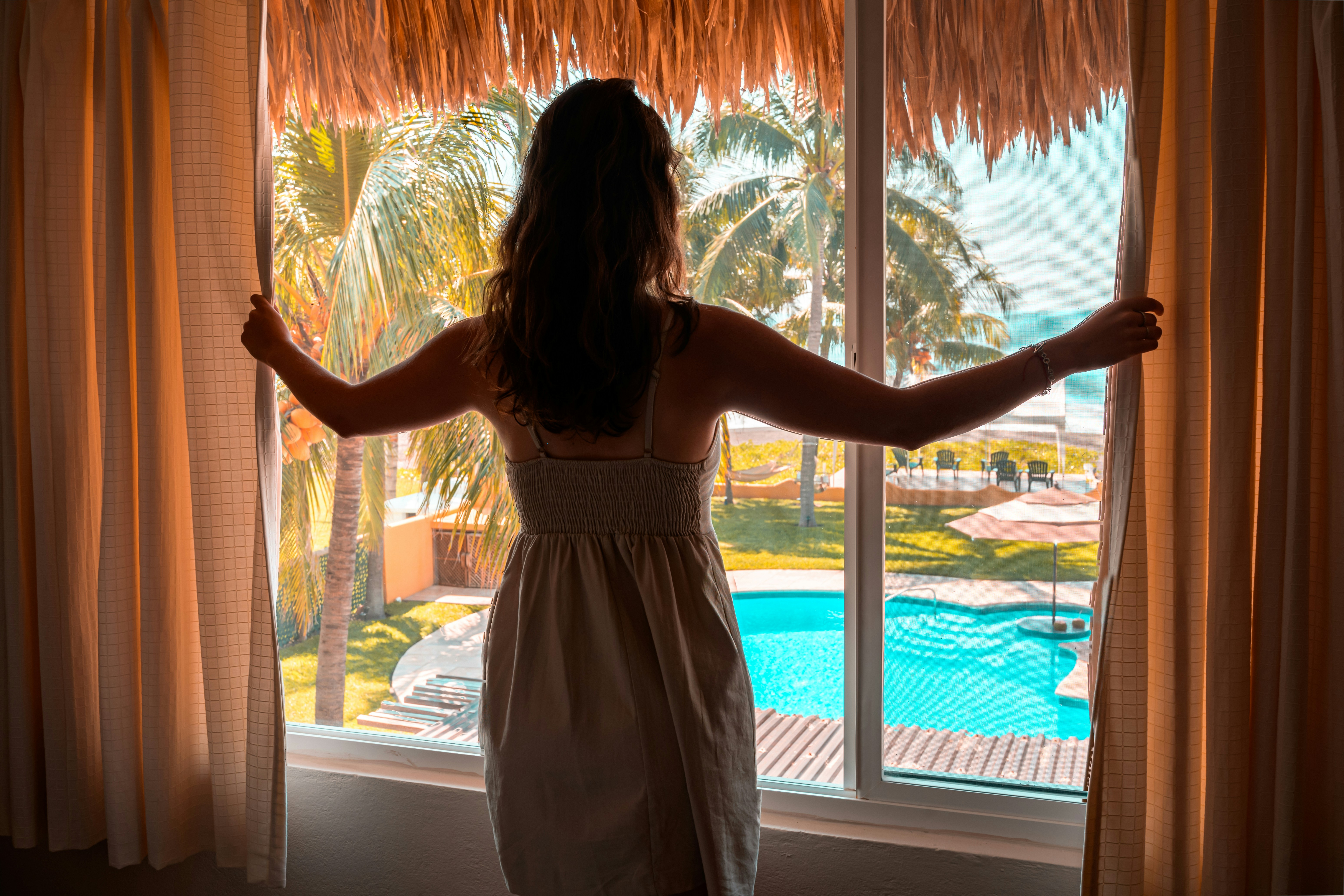 A person standing at a window in a hotel room | Source: Unsplash