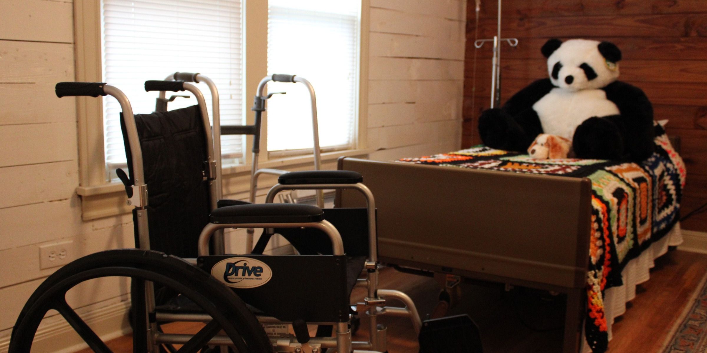 Wheelchair and hospital bed with a stuffed panda in a care room | Source: Pexels