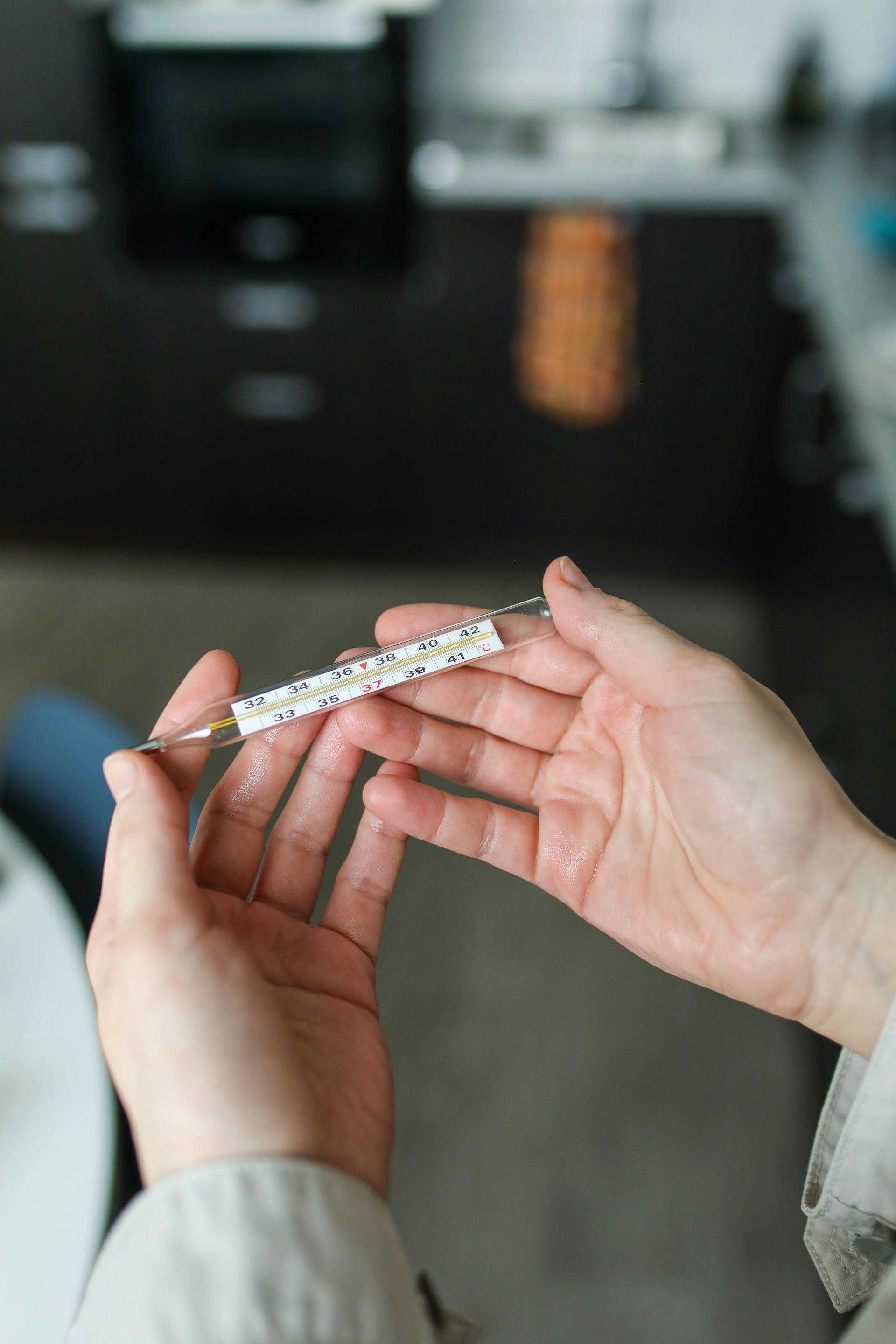 A person holding a thermometer | Source: Pexels