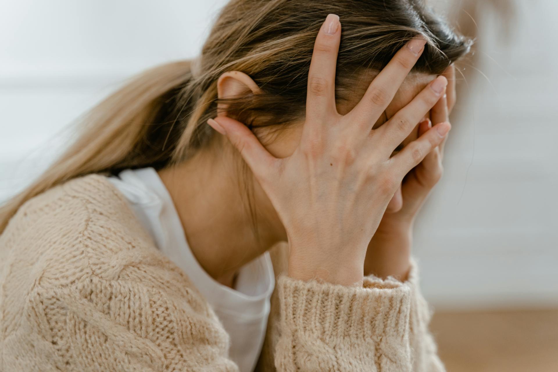 A woman with her head in her hands | Source: Pexels