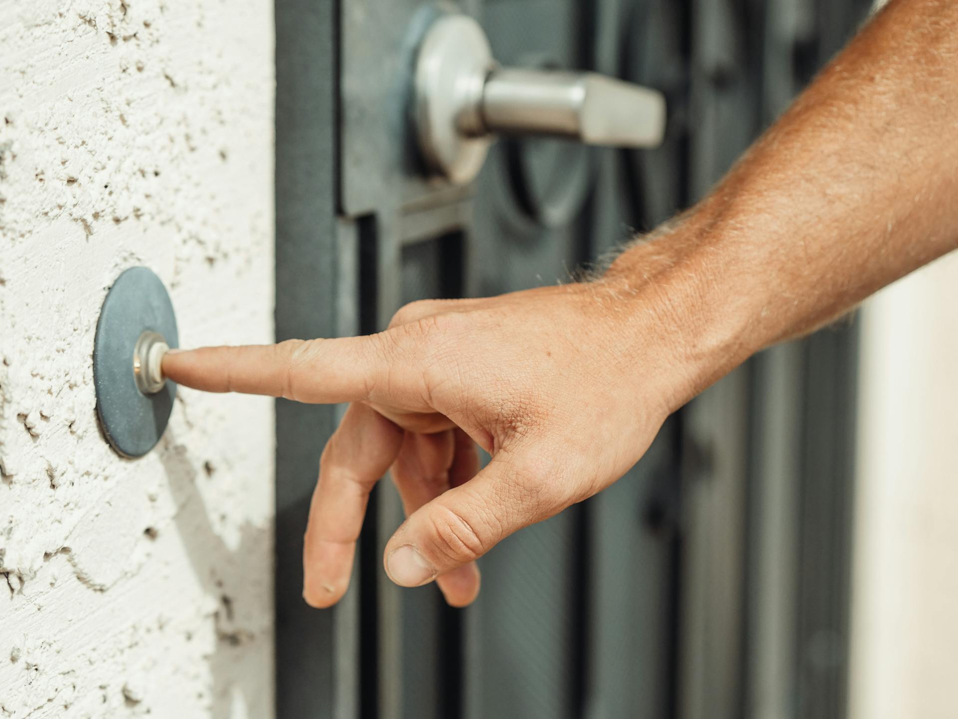 A person ringing a doorbell | Source: Pexels