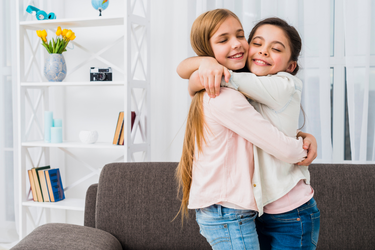 Two smiling girls hugging each other | Source: Freepik