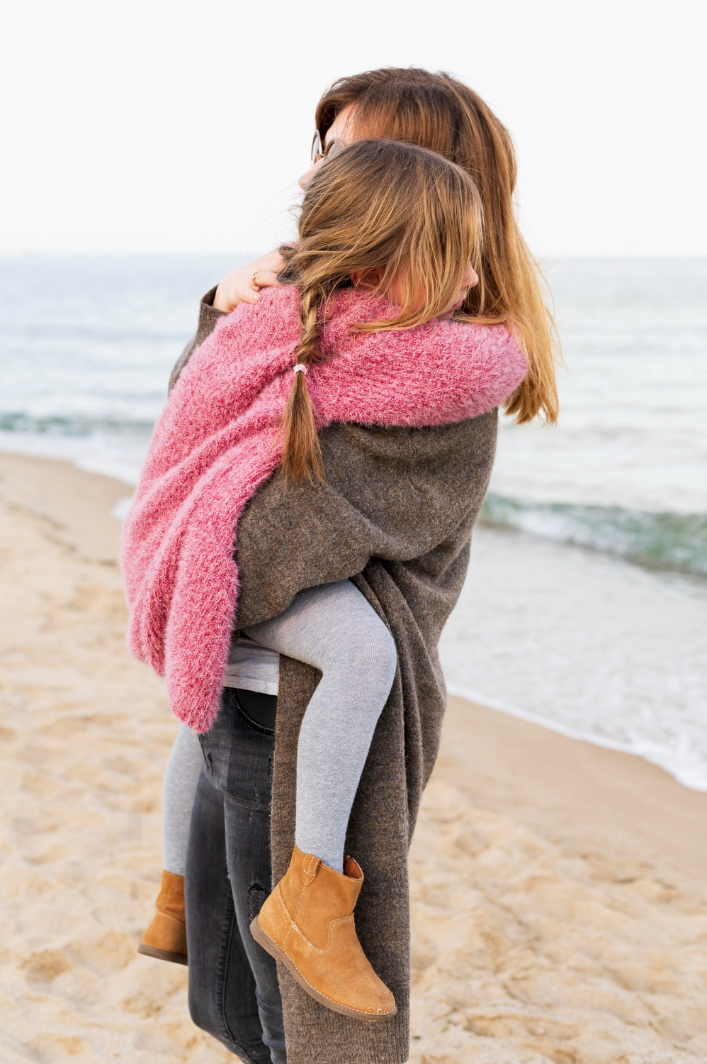 A woman carrying a little girl | Source: Freepik