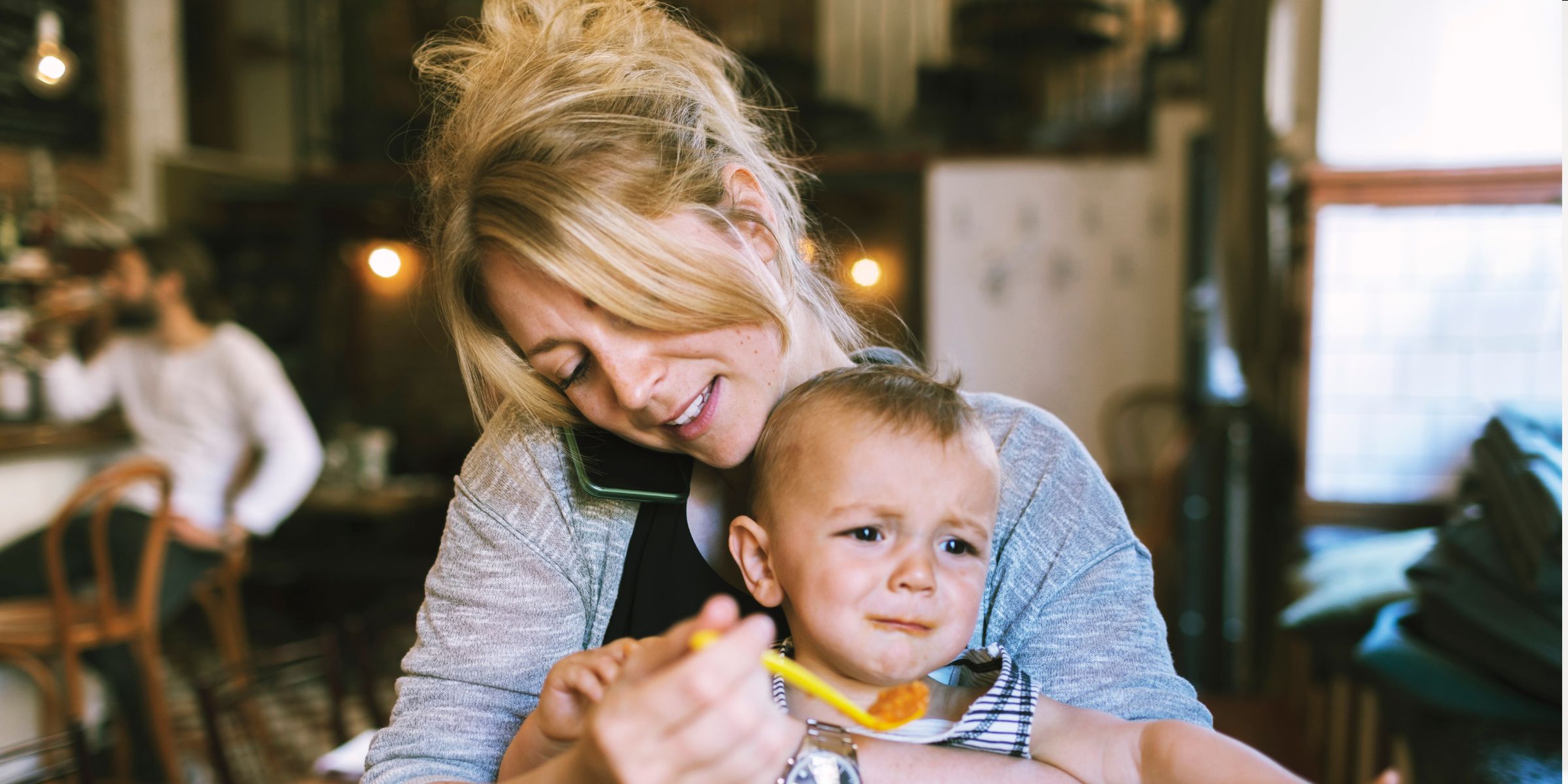 A mother trying to feed her baby boy in a restaurant | Source: Getty Images