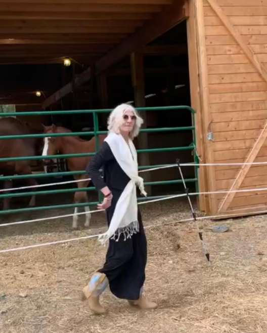 Ami Brown poses in front of a horse barn at North Star Ranch on April 7, 2023 | Source: Instagram/amibrownwolfpackmama