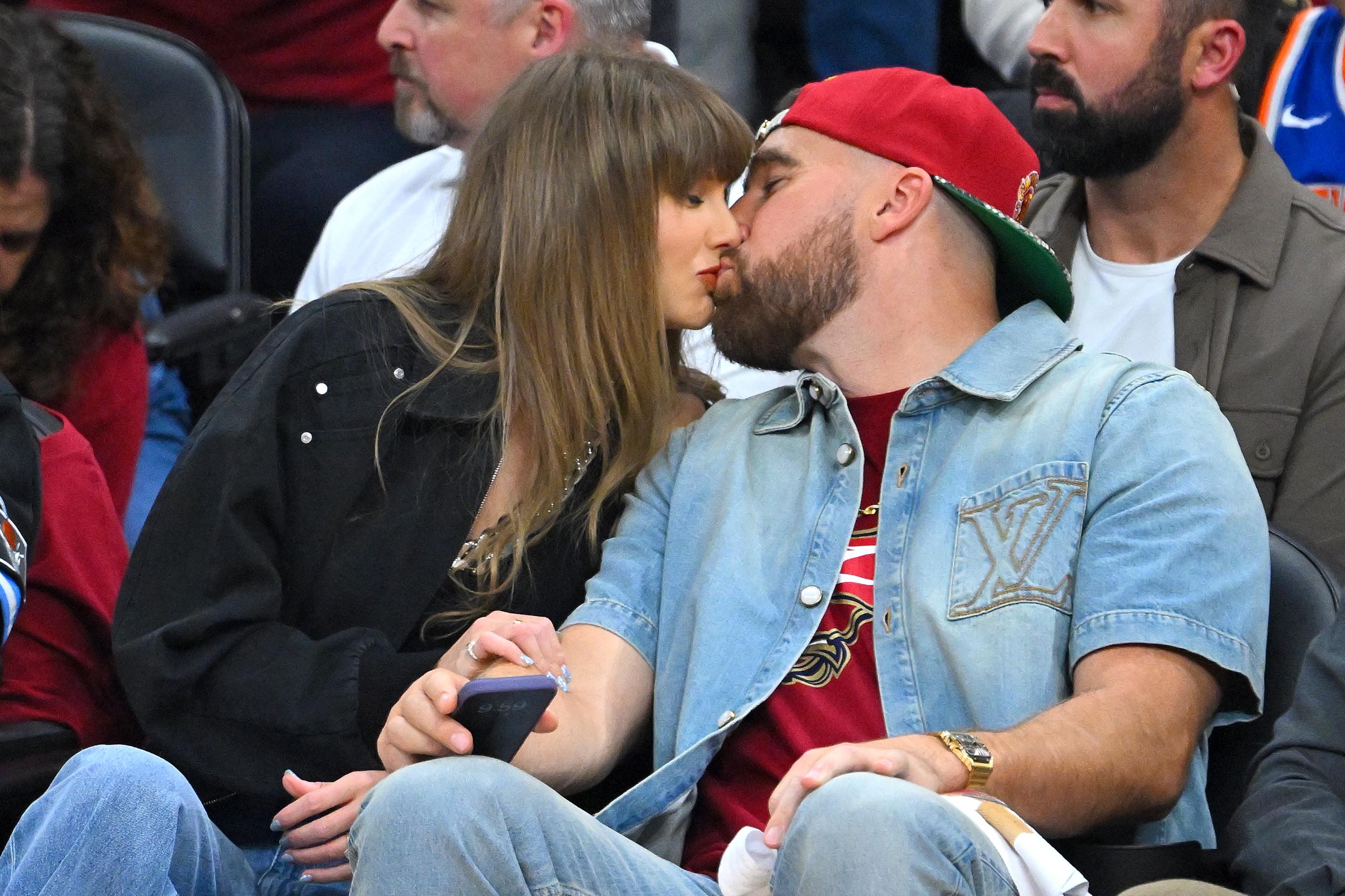 Taylor Swift and Travis Kelce kiss during Game 3 of the NBA Eastern Conference Finals in Cleveland, Ohio, on May 23, 2026. | Source: Getty Images